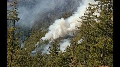 Smoke appears in the sky during a major forest fire near Kelvi village in Theog in Shimla district on Friday. (HT Photo)