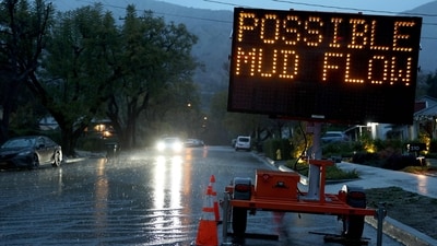 A driver in the rain approaches a sign that reads "Possible Mud Flow" as a strong atmospheric river storm affects the area in Sierra Madre, California. The storm is affecting a large part of Southern California. (Getty Images via AFP) A driver in the rain approaches a sign that reads "Possible Mud Flow" as a strong atmospheric river storm affects the area in Sierra Madre, California. The storm is affecting a large part of Southern California. (Getty Images via AFP)