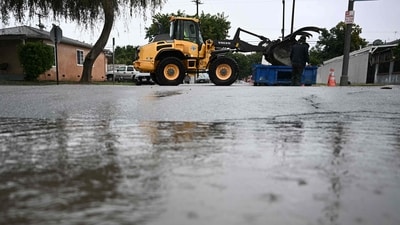 A Long Beach Public Works front loader loads dune outside a fire station in Long Beach, California, for locals to fill sand bags with after intense rains. (AFP) A Long Beach Public Works front loader loads dune outside a fire station in Long Beach, California, for locals to fill sand bags with after intense rains. (AFP)