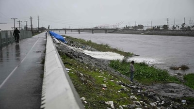 As massive downpour soaked southern California, a person in Long Beach, California, observes a homeless camp. (AFP) As massive downpour soaked southern California, a person in Long Beach, California, observes a homeless camp. (AFP)