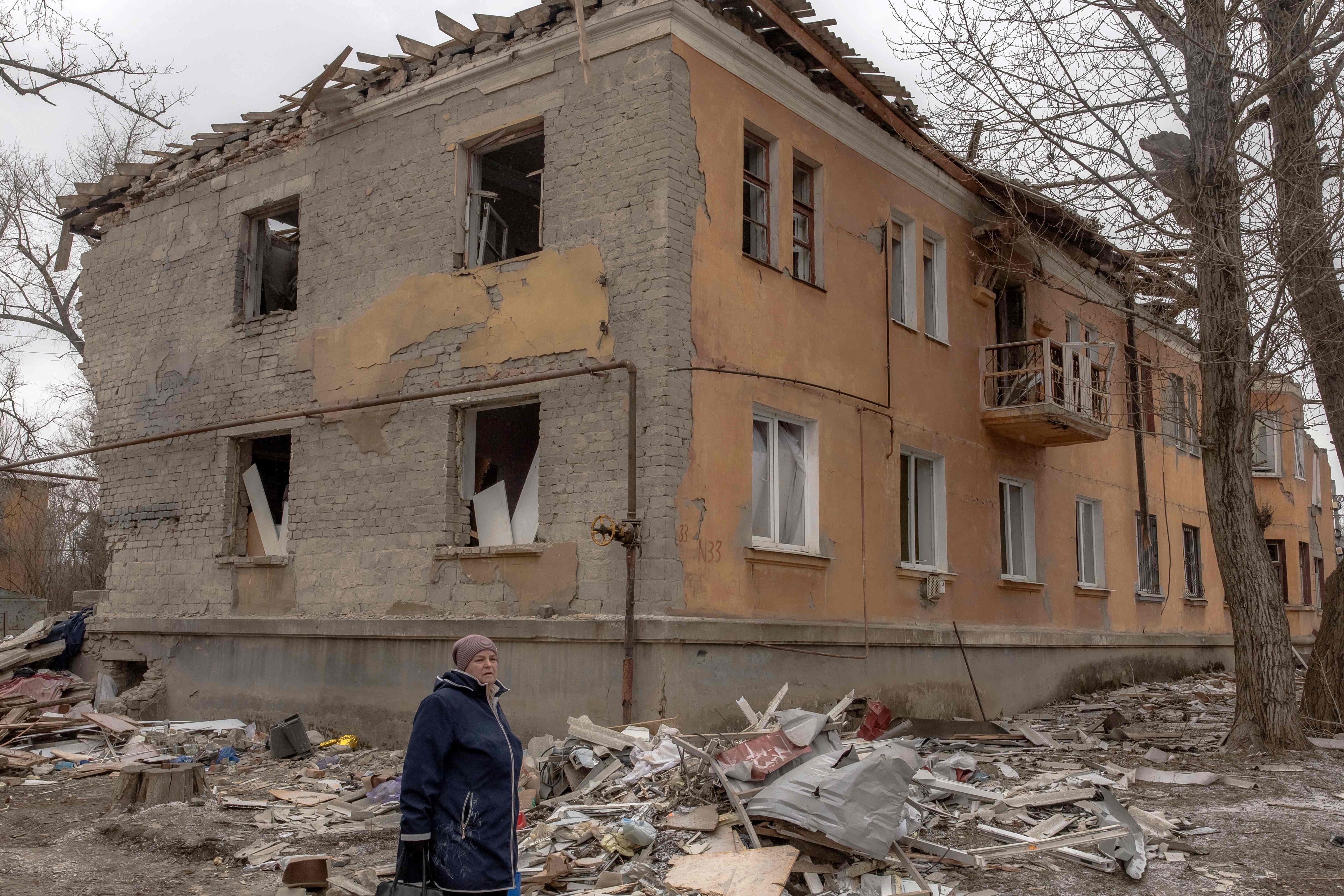 A woman walks past a residential building destroyed by shelling in Kostyantynivka, in the eastern Donetsk region, on February 7, amid the Russian invasion of Ukraine. (AFP) A woman walks past a residential building destroyed by shelling in Kostyantynivka, in the eastern Donetsk region, on February 7, amid the Russian invasion of Ukraine. (AFP)