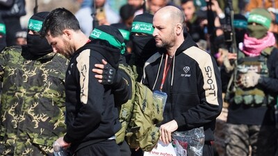 U.S.-Israeli Sagui Dekel-Chen and Iair Horn, hostages held in Gaza since the deadly October 7, 2023 attack, are escorted by Palestinian Hamas militants and Islamic Jihad militants as part of a ceasefire and a hostages-prisoners swap deal between Hamas and Israel. (Reuters)