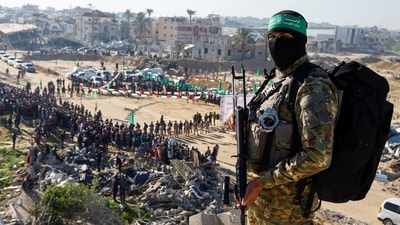 Palestinian Hamas militants stand guard on the day of the release of hostages held in Gaza since the deadly October 7, 2023 attack, as part of a ceasefire and a hostages-prisoners swap deal between Hamas and Israel in Khan Younis, in the southern Gaza Strip, (Reuters)