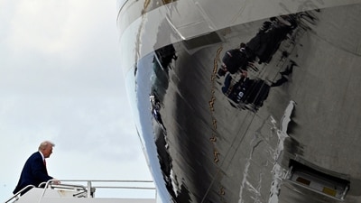 President Donald Trump boards Air Force One at Palm Beach International Airport in West Palm Beach, Florida on Sunday, en route to NASCAR's Daytona 500. (AP) President Donald Trump boards Air Force One at Palm Beach International Airport in West Palm Beach, Florida on Sunday, en route to NASCAR's Daytona 500. (AP)