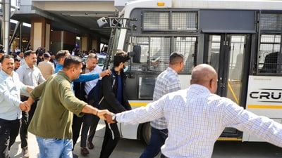 Police escort immigrants deported from the US upon their arrival at Ahmedabad airport, in Ahmedabad, Sunday, Feb. 16, 2025. They had landed in Amritsar a day earlier on a US military plane. (PTI)