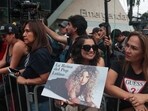 A fan holds a poster of Colombian singer Shakira as they stand outside Clinica Delgado Auna after Shakira was hospitalized with a stomach issue, forcing her to cancel her Sunday show, in Lima, Peru February 16, 2025. REUTERS/Sebastian Castaneda