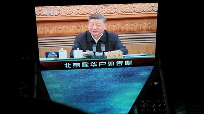 A giant screen shows news footage of  Chinese President Xi Jinping attending a symposium on private enterprises, at a shopping complex in Beijing, China, February 17, 2025. REUTERS/Florence Lo