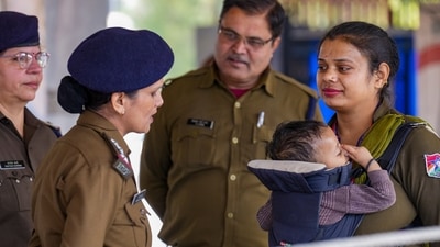 RPF constable Rina carries her child, as she interacts with other personnel while keeping vigil at the New Delhi Railway Station, in New Delhi, Monday, Feb. 17, 2025. (PTI) RPF constable Rina carries her child, as she interacts with other personnel while keeping vigil at the New Delhi Railway Station, in New Delhi, Monday, Feb. 17, 2025. (PTI)