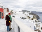 Tourists enjoy the view from the village of Oia, as increased seismic activity continues on the island of Santorini, Greece.