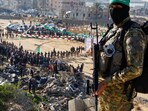 Palestinian Hamas militants stand guard on the day of the release of hostages held in Gaza since the deadly October 7, 2023 attack, as part of a ceasefire and a hostages-prisoners swap deal between Hamas and Israel in Khan Younis, in the southern Gaza Strip,