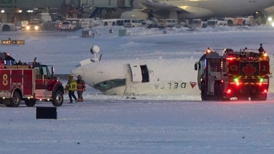 A Delta Airlines plane sits on its roof after crashing upon landing at Toronto Pearson Airport in Toronto, Ontario, on February 17, 2025. (Photo by Geoff Robins / AFP) (AFP) A Delta Airlines plane sits on its roof after crashing upon landing at Toronto Pearson Airport in Toronto, Ontario, on February 17, 2025. (Photo by Geoff Robins / AFP) (AFP)