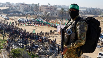 Palestinian Hamas militants stand guard on the day of the release of hostages held in Gaza since the deadly October 7, 2023 attack, as part of a ceasefire and a hostages-prisoners swap deal between Hamas and Israel in Khan Younis, in the southern Gaza Strip, (Reuters)