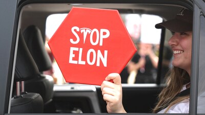 NORTH HOLLYWOOD, CALIFORNIA - FEBRUARY 17: A protester holds a 'Stop Elon' sign written with the Tesla logo at a rally against the Trump administration during a "Not My President's Day" protest on February 17, 2025 in North Hollywood, California. Protests are being held in cities across the nation on Presidents' Day against what the organizers say are "the anti-democratic and illegal actions of the Trump administration." Mario Tama/Getty Images/AFP (Photo by MARIO TAMA / GETTY IMAGES NORTH AMERICA / Getty Images via AFP) (Getty Images via AFP) NORTH HOLLYWOOD, CALIFORNIA - FEBRUARY 17: A protester holds a 'Stop Elon' sign written with the Tesla logo at a rally against the Trump administration during a "Not My President's Day" protest on February 17, 2025 in North Hollywood, California. Protests are being held in cities across the nation on Presidents' Day against what the organizers say are "the anti-democratic and illegal actions of the Trump administration." Mario Tama/Getty Images/AFP (Photo by MARIO TAMA / GETTY IMAGES NORTH AMERICA / Getty Images via AFP) (Getty Images via AFP)