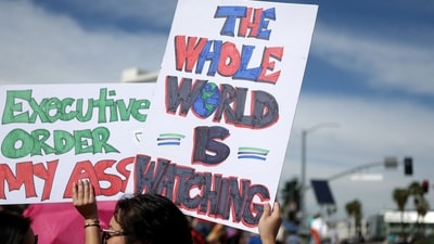 NORTH HOLLYWOOD, CALIFORNIA - FEBRUARY 17: A protester carries a 'The Whole World Is Watching' sign while marching against the Trump administration during a "Not My President's Day" protest on February 17, 2025 in North Hollywood, California. Protests are being held in cities across the nation on Presidents' Day against what the organizers say are "the anti-democratic and illegal actions of the Trump administration." Mario Tama/Getty Images/AFP (Photo by MARIO TAMA / GETTY IMAGES NORTH AMERICA / Getty Images via AFP) (Getty Images via AFP) NORTH HOLLYWOOD, CALIFORNIA - FEBRUARY 17: A protester carries a 'The Whole World Is Watching' sign while marching against the Trump administration during a "Not My President's Day" protest on February 17, 2025 in North Hollywood, California. Protests are being held in cities across the nation on Presidents' Day against what the organizers say are "the anti-democratic and illegal actions of the Trump administration." Mario Tama/Getty Images/AFP (Photo by MARIO TAMA / GETTY IMAGES NORTH AMERICA / Getty Images via AFP) (Getty Images via AFP)