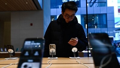 A man tests an iPhone 16 in an Apple store. Apple has been diversifying production beyond China, most recently beginning production of its AirPods wireless earphones on a trial basis in India. (AFP) A man tests an iPhone 16 in an Apple store. Apple has been diversifying production beyond China, most recently beginning production of its AirPods wireless earphones on a trial basis in India. (AFP)