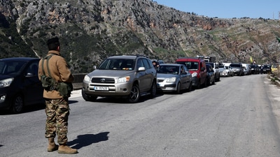 Cars queue as they seek to enter the southern Lebanese village of Kfar Kila. (REUTERS)