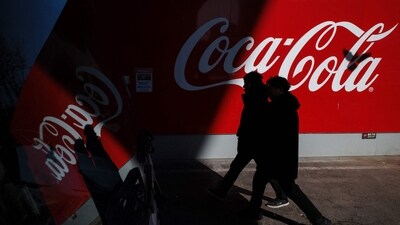 Pedestrians walk past a Coca-Cola logo in Seoul on February 6, 2025. (Anthony Wallace/AFP) Pedestrians walk past a Coca-Cola logo in Seoul on February 6, 2025. (Anthony Wallace/AFP)