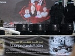 Palestinian militant group Hamas fighters stand on stage next to the coffins of the four Israeli hostages during the handing them over to the Red Cross in Khan Yunis in southern Gaza on February 20, 2025.&nbsp;