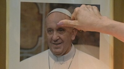 A faithful touches a portrait of Pope Francis during a mass at the Basilica San Jose de Flores to pray for his health in Buenos Aires. (Photo by JUAN MABROMATA / AFP) A faithful touches a portrait of Pope Francis during a mass at the Basilica San Jose de Flores to pray for his health in Buenos Aires. (Photo by JUAN MABROMATA / AFP)