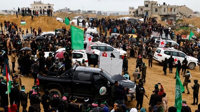 Palestinian militants and members of the Red Cross gather near vehicles on the day Hamas hands over deceased hostages Oded Lifschitz, Shiri Bibas and her two children Kfir and Ariel Bibas, seized during the deadly October 7, 2023 attack, to the Red Cross, as part of a ceasefire and hostages-prisoners swap deal between Hamas and Israel, in Khan Younis in the southern Gaza Strip February 20, 2025.&nbsp; (Reuters)