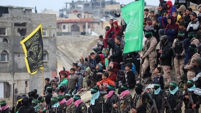 Palestinian Hamas militants gather at the site of the handing over the bodies of four Israeli hostages in Khan Yunis in the southern Gaza on February 20, 2025. (AFP) Palestinian Hamas militants gather at the site of the handing over the bodies of four Israeli hostages in Khan Yunis in the southern Gaza on February 20, 2025. (AFP)