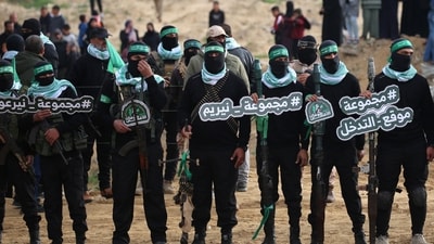 Palestinian Hamas militants gather at the site of the handing over of the bodies of four Israeli hostages in Khan Yunis in southern Gaza on February 20, 2025. (AFP) Palestinian Hamas militants gather at the site of the handing over of the bodies of four Israeli hostages in Khan Yunis in southern Gaza on February 20, 2025. (AFP)