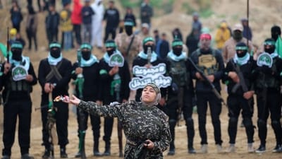 A Palestinian girl throws flowers as Hamas militants gather at the site of the handing over of the bodies of four Israeli hostages in Khan Yunis in southern Gaza on Thursday. (AFP) A Palestinian girl throws flowers as Hamas militants gather at the site of the handing over of the bodies of four Israeli hostages in Khan Yunis in southern Gaza on Thursday. (AFP)