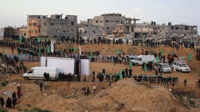 Palestinian Hamas militants gather at the site of the handing over the bodies of four Israeli hostages in Khan Yunis in the southern Gaza on February 20, 2025. (AFP) Palestinian Hamas militants gather at the site of the handing over the bodies of four Israeli hostages in Khan Yunis in the southern Gaza on February 20, 2025. (AFP)