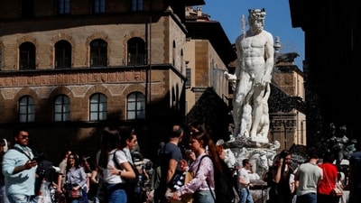 People walk past the Fountain of Neptune (Fontana del Nettuno) in Signoria Square in Florence, Italy. (Reuters)