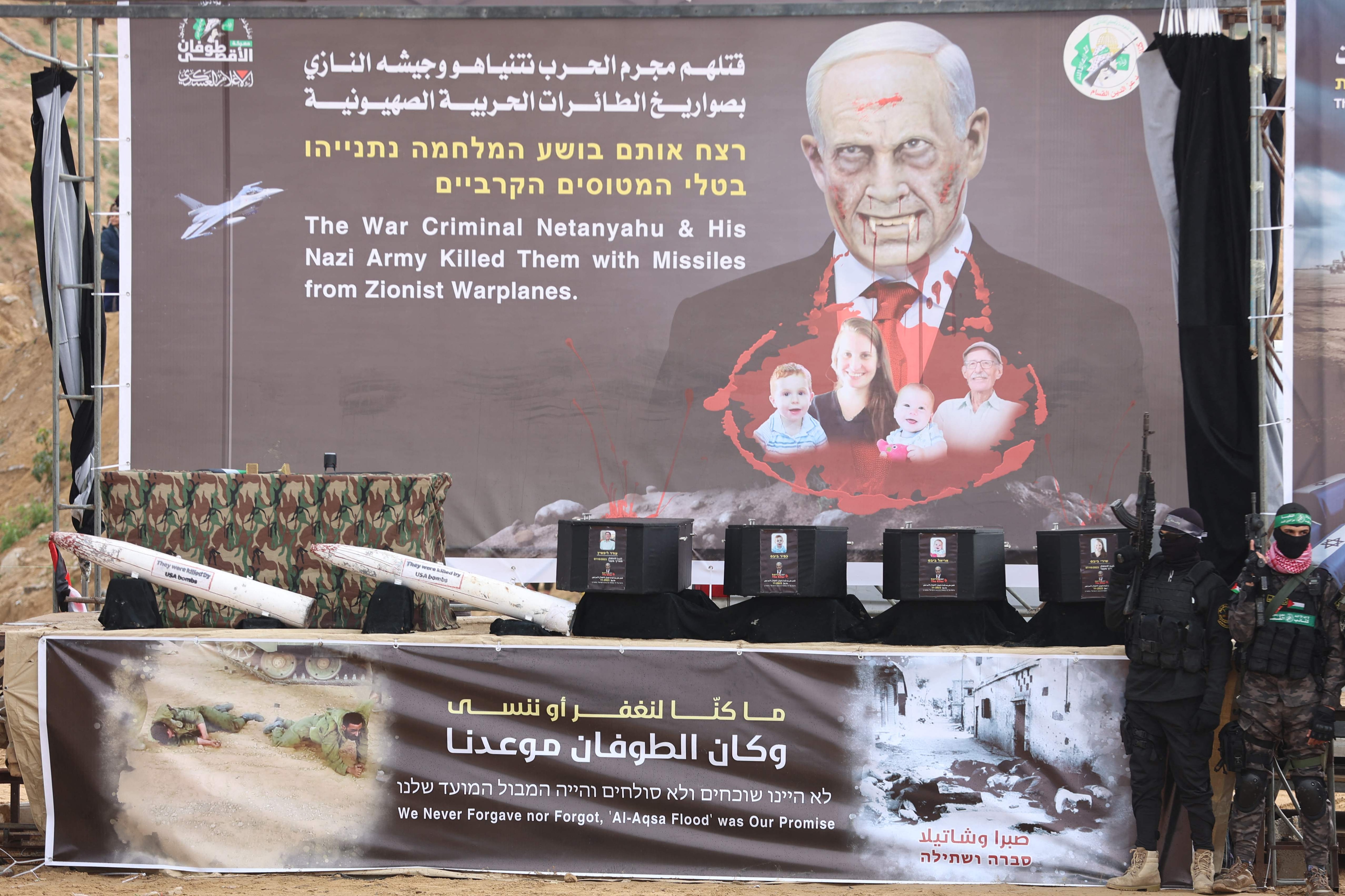 TOPSHOT - Armed Palestinian militants stand next to the coffins on stage before handing over the bodies of four Israeli hostages to the Red Cross in Khan Yunis in the southern Gaza on February 20, 2025. Hamas handed over on February 20 coffins believed to contain the bodies of four Israeli hostages, including those of the Bibas family who became symbols of the ordeal that has gripped Israel since the Gaza war began. The transfer of the bodies is the first by Hamas since its October 7, 2023 attack on Israel triggered the war, and is taking place under a fragile ceasefire that has seen living hostages exchanged for Palestinians held in Israeli prisons. (Photo by Omar AL-QATTAA / AFP)(AFP) TOPSHOT - Armed Palestinian militants stand next to the coffins on stage before handing over the bodies of four Israeli hostages to the Red Cross in Khan Yunis in the southern Gaza on February 20, 2025. Hamas handed over on February 20 coffins believed to contain the bodies of four Israeli hostages, including those of the Bibas family who became symbols of the ordeal that has gripped Israel since the Gaza war began. The transfer of the bodies is the first by Hamas since its October 7, 2023 attack on Israel triggered the war, and is taking place under a fragile ceasefire that has seen living hostages exchanged for Palestinians held in Israeli prisons. (Photo by Omar AL-QATTAA / AFP)(AFP)