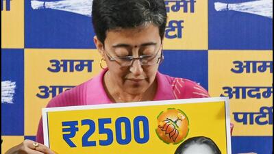 Atishi shows placards accusing BJP of false promises to Delhi women in a press conference on Friday. (Vipin Kumar/HT Photo) Atishi shows placards accusing BJP of false promises to Delhi women in a press conference on Friday. (Vipin Kumar/HT Photo)