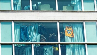 Migrants deported from the US gesture as they look out the window of the Decapolis Hotel where they are temporarily staying in Panama City. (AFP) Migrants deported from the US gesture as they look out the window of the Decapolis Hotel where they are temporarily staying in Panama City. (AFP)