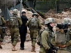 Israeli soldiers detain a youth after preventing access to Palestinians waiting to be let back into the Jenin camp for refugees during an ongoing military operation, on February 19, 2025.