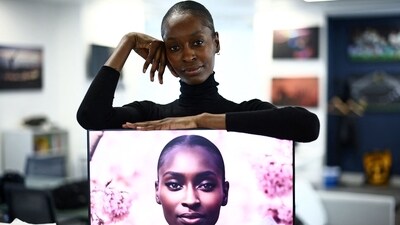 London-based model Alexsandrah Gondora poses for a photograph with her on-screen AI twin "Alex", created by digital modelling agency, The Diigitals in the AFP offices in London on February 21, 2025. My artificial intelligence (AI) replica "basically does the hard work so I don't have to do it," jokes London-based model Alexsandrah Gondora, who enjoys being able to "be in two places at once." (Henry Nicholls/AFP) London-based model Alexsandrah Gondora poses for a photograph with her on-screen AI twin "Alex", created by digital modelling agency, The Diigitals in the AFP offices in London on February 21, 2025. My artificial intelligence (AI) replica "basically does the hard work so I don't have to do it," jokes London-based model Alexsandrah Gondora, who enjoys being able to "be in two places at once." (Henry Nicholls/AFP)