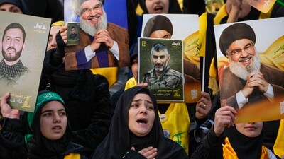 Mourners react as a trailer carrying the coffins containing the bodies of Hezbollah's former leader Hassan Nasrallah and his cousin and successor Hashem Safieddine drives through the crowd at the beginning of a funeral procession in the Sports City Stadium in Beirut, Lebanon on Sunday. (AP) Mourners react as a trailer carrying the coffins containing the bodies of Hezbollah's former leader Hassan Nasrallah and his cousin and successor Hashem Safieddine drives through the crowd at the beginning of a funeral procession in the Sports City Stadium in Beirut, Lebanon on Sunday. (AP)