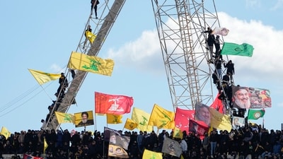 Mourners wave Hezbollah flags, right, as the trailer carrying the coffins containing the bodies of Hezbollah's former leader Hassan Nasrallah and his cousin and successor Hashem Safieddine drives through the crowd at the beginning of a funeral procession in the Sports City Stadium in Beirut Lebanon on Sunday. (AP) Mourners wave Hezbollah flags, right, as the trailer carrying the coffins containing the bodies of Hezbollah's former leader Hassan Nasrallah and his cousin and successor Hashem Safieddine drives through the crowd at the beginning of a funeral procession in the Sports City Stadium in Beirut Lebanon on Sunday. (AP)