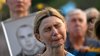 Members of the Ukrainian community in Australia react as they hold photographs during a vigil in central Sydney on February 24, 2025, marking the third anniversary of Russia's invasion of Ukraine. (AFP) Members of the Ukrainian community in Australia react as they hold photographs during a vigil in central Sydney on February 24, 2025, marking the third anniversary of Russia's invasion of Ukraine. (AFP)
