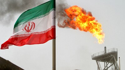 FILE PHOTO: A gas flare on an oil production platform is seen alongside an Iranian flag in the Gulf July 25, 2005. (REUTERS)