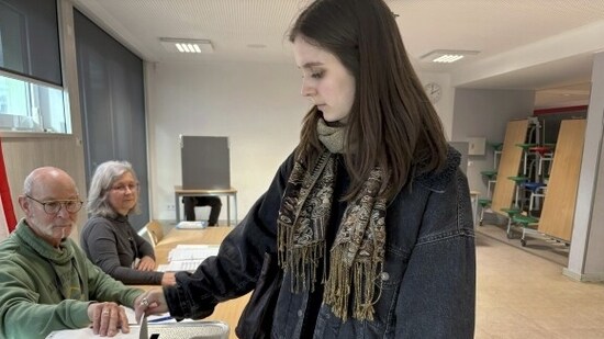 On Sunday, Gesa Schönwolff volunteered at a Berlin voting place, helping voters enter and verifying their identification. After then, the 18-year-old took a pause and cast her first ballot. (AP)