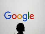 A woman walks by a giant screen with a logo at an event at the Paris Google Lab on the sidelines of the AI Action Summit in Paris, Sunday, Feb. 9, 2025.