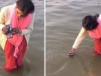 A woman's peculiar method of giving her husband a digital holy dip at the Mahakumbh Mela has gone viral. A woman's peculiar method of giving her husband a digital holy dip at the Mahakumbh Mela has gone viral.