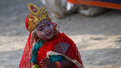 A child dressed as Hindu deity Krishna sits near Sangam, the confluence of Ganges, Yamuna and mythical Saraswati rivers, on the eve of Maha Shivaratri during the Maha Kumbh Mela festival in Prayagraj on February 25, 2025. (AFP) A child dressed as Hindu deity Krishna sits near Sangam, the confluence of Ganges, Yamuna and mythical Saraswati rivers, on the eve of Maha Shivaratri during the Maha Kumbh Mela festival in Prayagraj on February 25, 2025. (AFP)