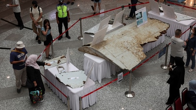 Visitors looking at the wreckage of an aircraft, believed to be from the missing Malaysia Airlines flight MH370, during the 10th anniversary event of its disappearance. (File Image/Reuters)