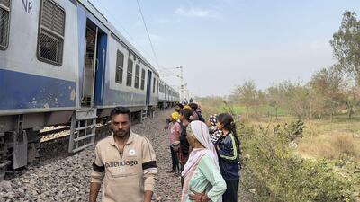 Passengers wait near the train derailed between Nilokheri and Taroari railway stations on Tuesday near Karnal on Tuesday. (HT Photo)