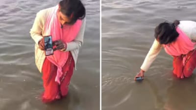A woman's peculiar method of giving her husband a digital holy dip at the Mahakumbh Mela has gone viral. (Instagram/adityachauhan7338) A woman's peculiar method of giving her husband a digital holy dip at the Mahakumbh Mela has gone viral. (Instagram/adityachauhan7338)