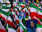 People hold flags and pictures of Maryam Rajavi, as supporters of Iranian opposition group National Council of Resistance of Iran (NCRI) gather to protest against the nuclear program.