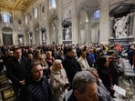People gather to pray for Pope Francis, who is in critical condition battling double pneumonia, inside Archcathedral of Saint John in Lateran