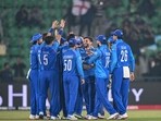 Afghanistan's Azmatullah Omarzai (C) celebrates with teammates after taking a catch to dismiss England's Jamie Smith 