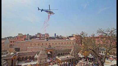 A helicopter showers flower petals on devotees on Mahashivratri at Kashi Vishwanath Temple, in Varanasi on Wednesday. (ANI Photo) A helicopter showers flower petals on devotees on Mahashivratri at Kashi Vishwanath Temple, in Varanasi on Wednesday. (ANI Photo)