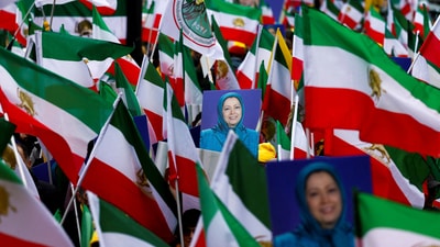 People hold flags and pictures of Maryam Rajavi, as supporters of Iranian opposition group National Council of Resistance of Iran (NCRI) gather to protest against the nuclear program. (REUTERS)